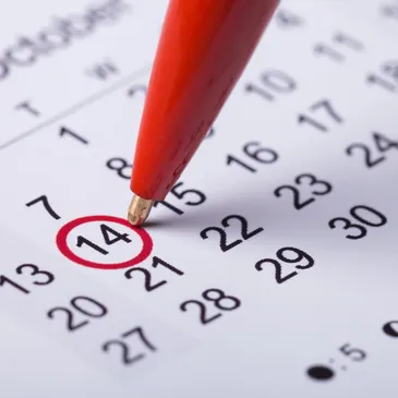 Picture on a red pen marking a date on a calendar